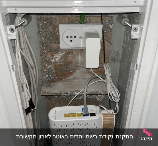 נתב וכבלי תקשורת מותקנים בתוך ארון תקשורת ביתי בקיר
